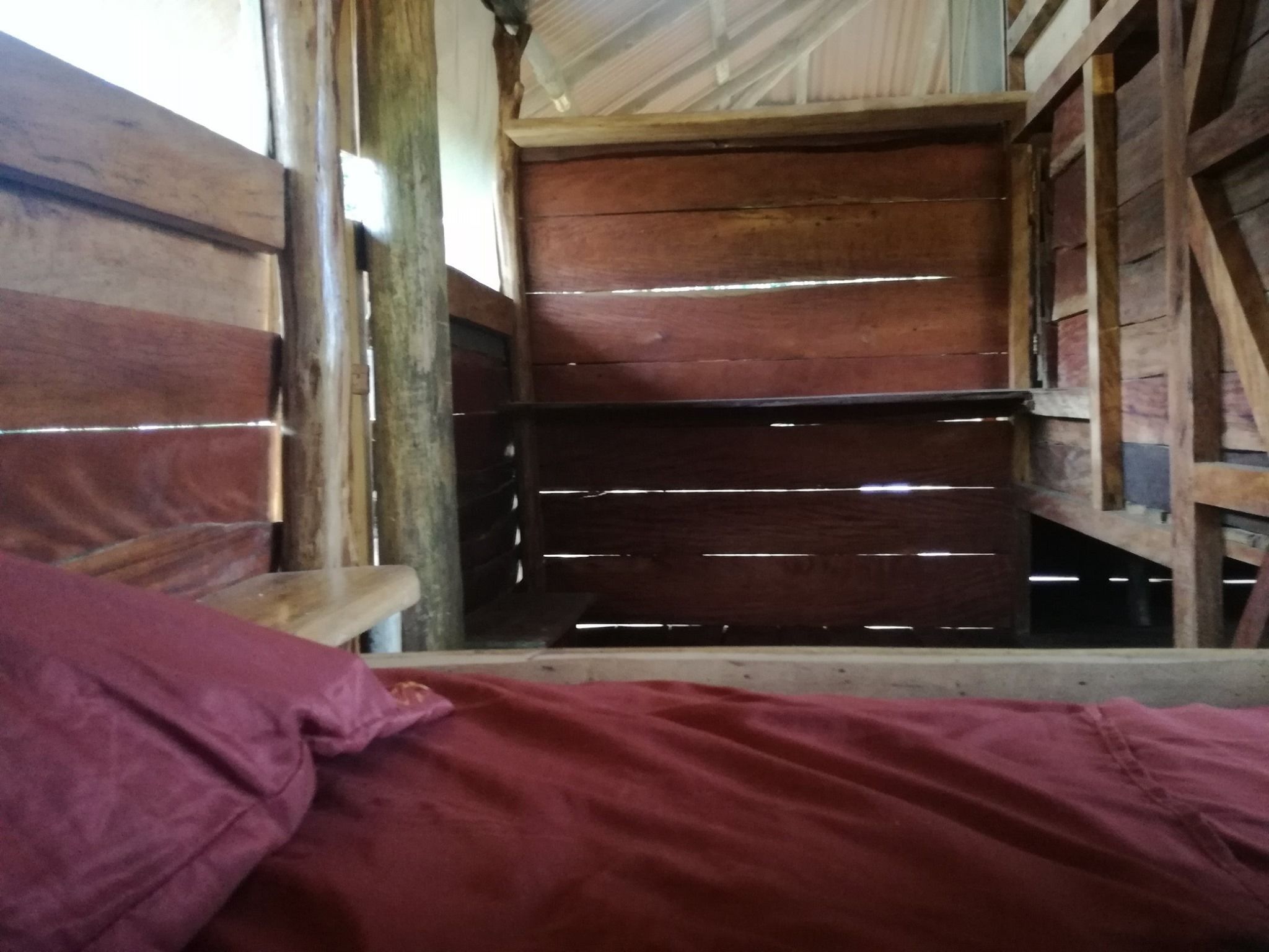 Un intérieur rustique en bois, avec un lit et un banc.