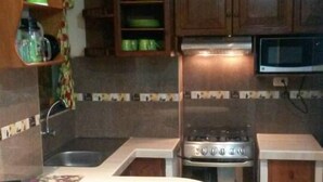 Une cuisine avec un îlot central, une cuisinière et un four à micro-ondes.