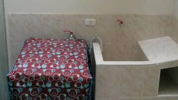 A bathroom with a toilet, a sink, and a shower area.