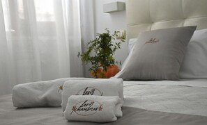 A neatly made bed with white linens and two pillows, one with embroidered text. - Les 3 Chambres (Lecce)