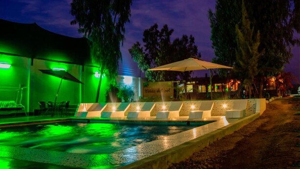 A pool area with a sunken seating area and a covered section.
