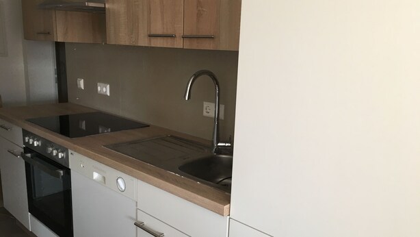 A kitchen with a stove, oven, sink, and wooden cabinets. - Monteurzimmer Leimen (Leimen)
