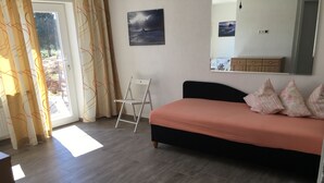 A bedroom with a bed, a dresser, a mirror, and a window with curtains. - Monteurzimmer Leimen (Leimen)