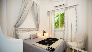 Une chambre à coucher avec un lit, une chaise et un appareil de climatisation.
