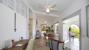 Une pièce spacieuse comprenant un coin repas, un ventilateur de plafond et une vue sur l’extérieur.