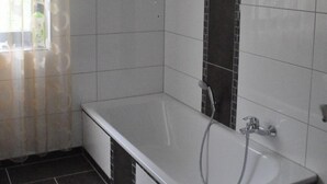 Un bagno moderno con una vasca, una doccia e un water.