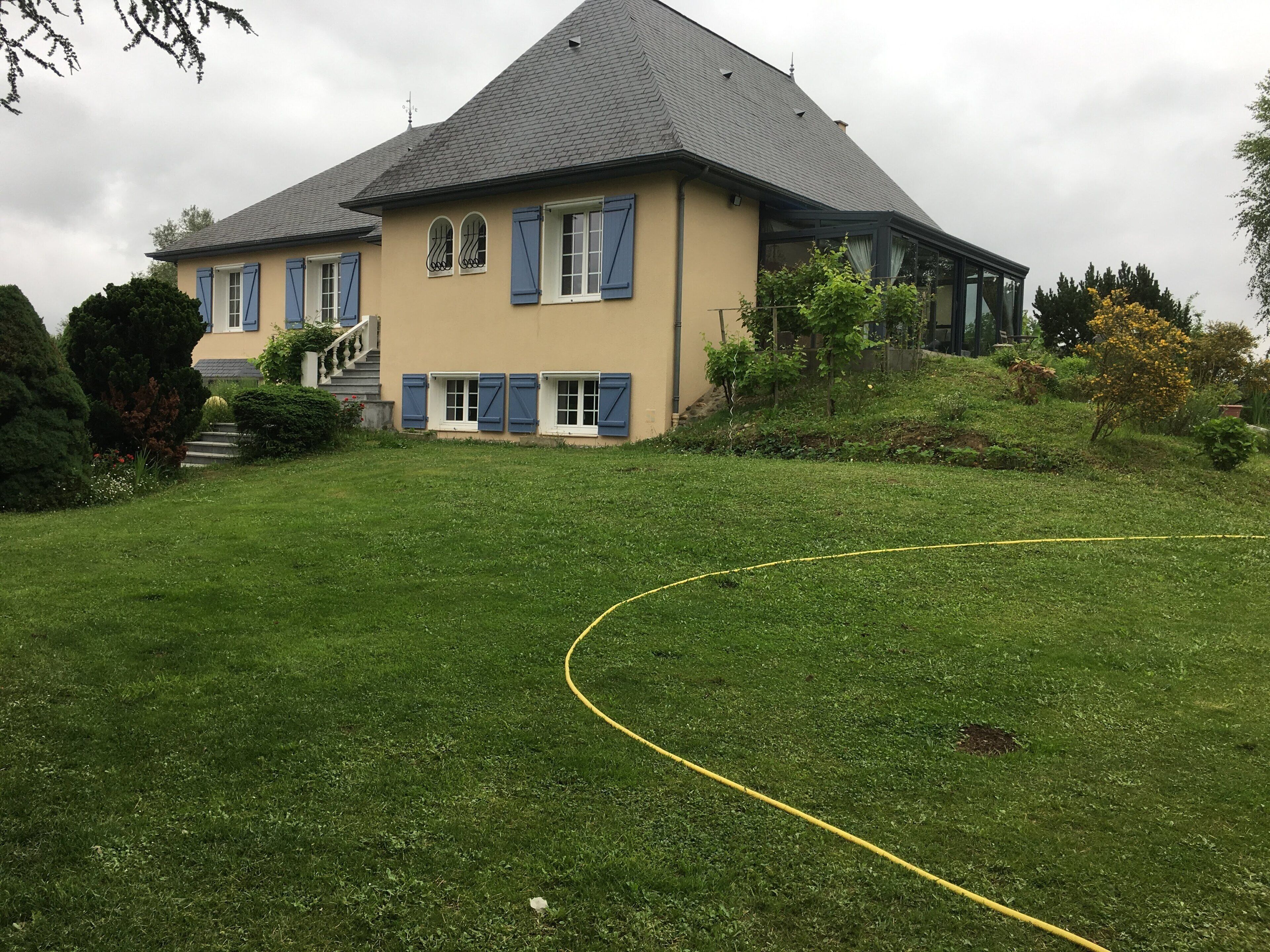 Une maison à deux étages, dotée d’un toit en pente, d’un porche à l’avant et d’une pelouse bien entretenue.