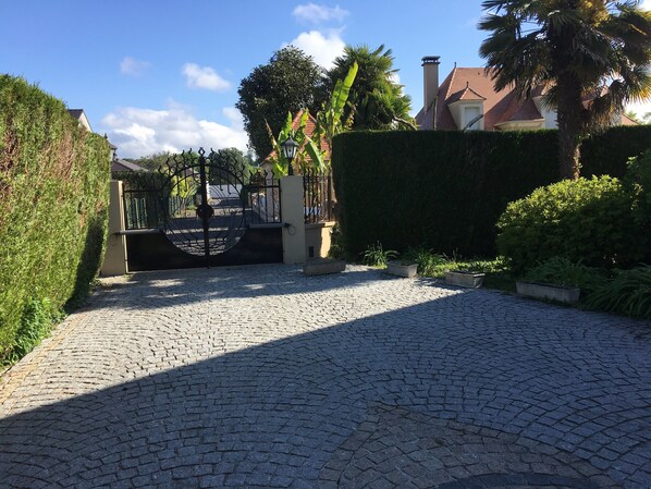 Un camino empedrado que conduce a una entrada con portón metálico.