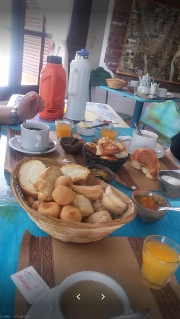 A breakfast table with various food items, including bread, pastries, and orange juice.