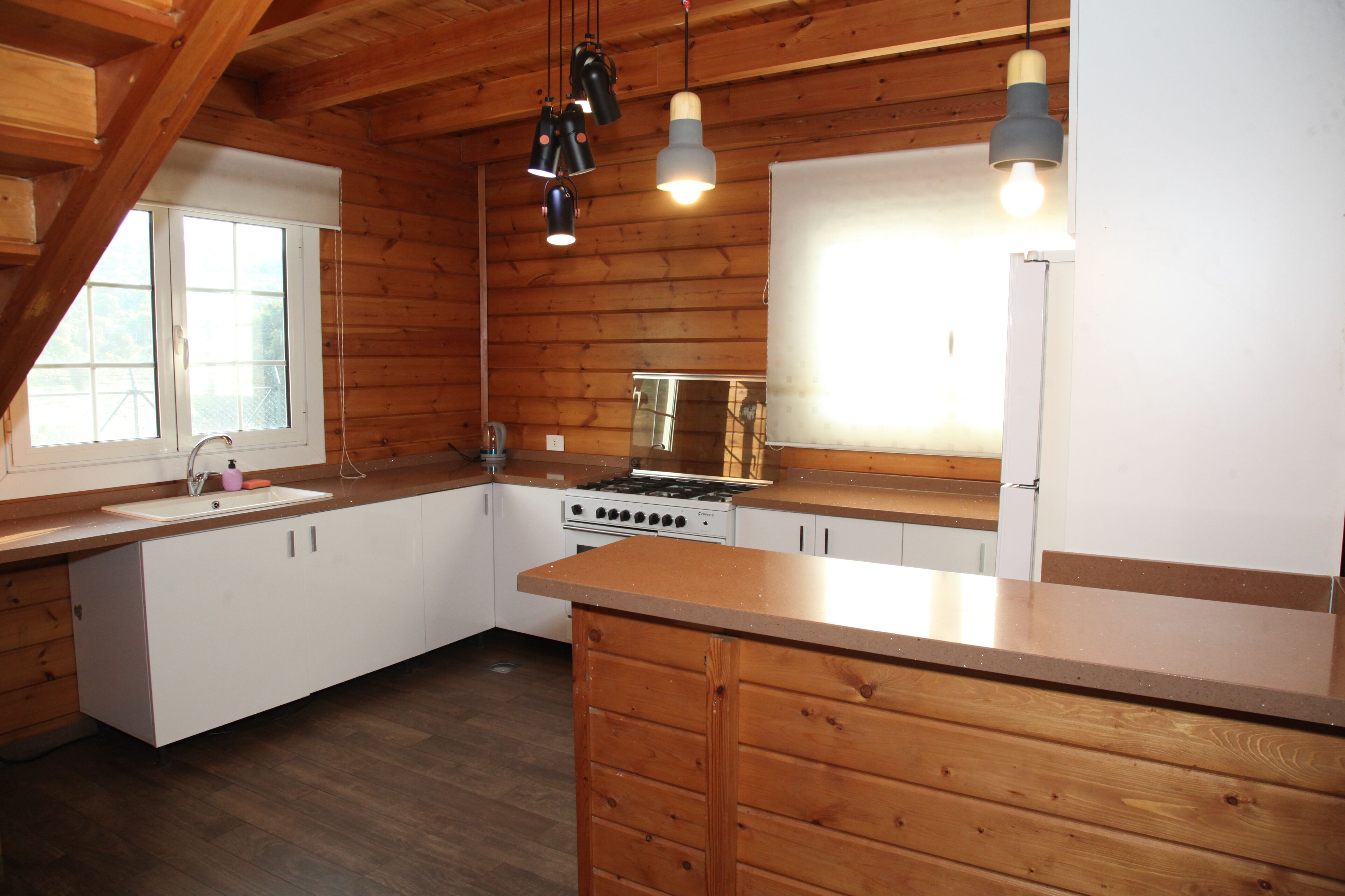 A kitchen with wooden cabinets, a stove, and a sink.