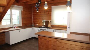 A kitchen with wooden cabinets, a stove, and a sink.