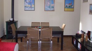 A dining area with a table and four chairs, a black cabinet, and wall-mounted artwork.