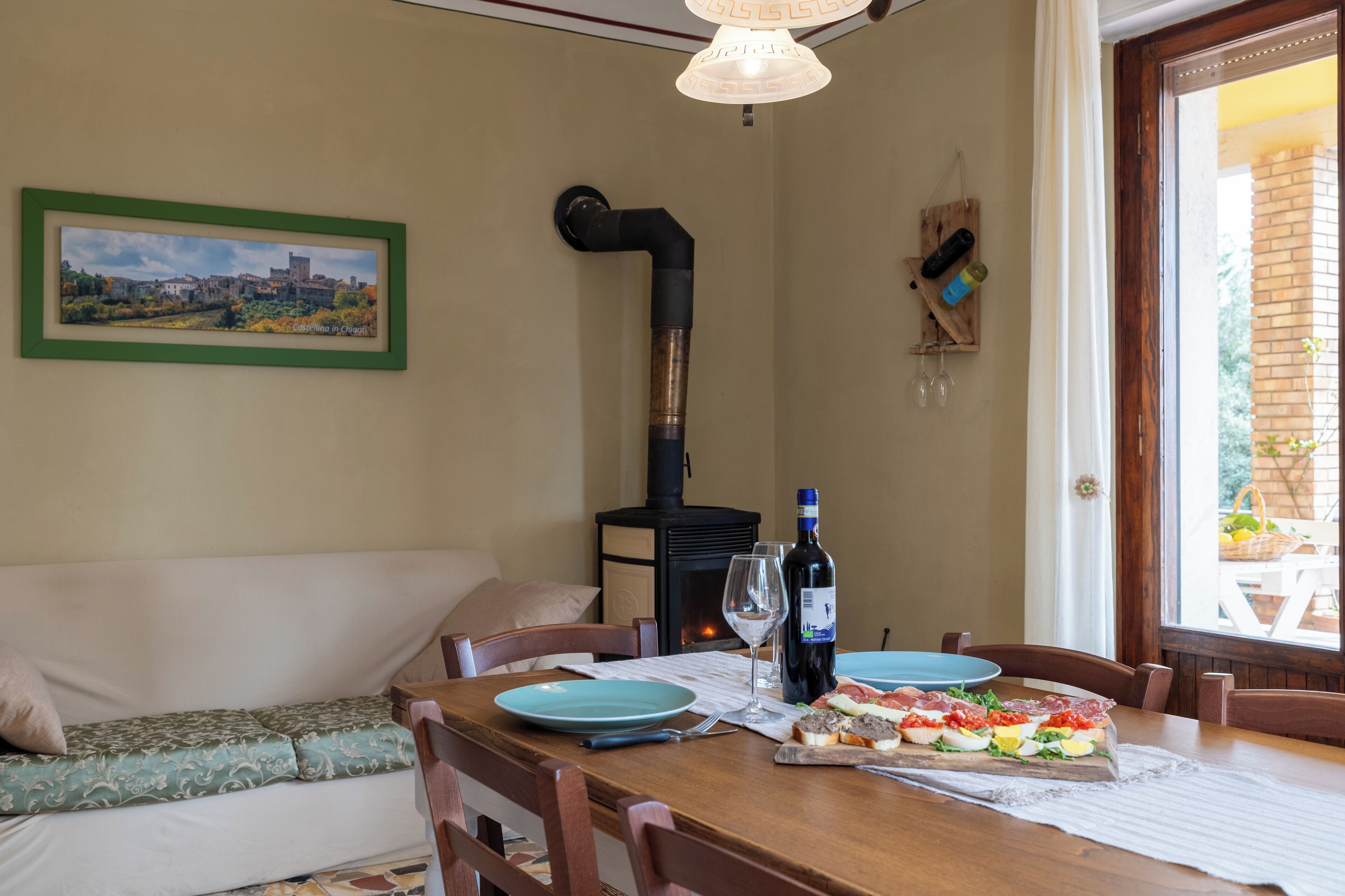 Un comedor con mesa de madera, sillas, un sofá, chimenea y ventana con vistas.