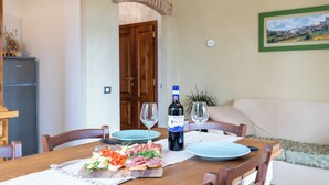 A dining table set with plates, glasses, a bottle of wine, and a variety of food items. - Casa Bruna - Cipresseta del Chianti (Castellina in Chianti, Siena)