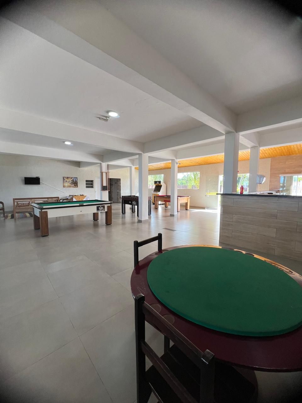 A spacious indoor recreational area with a pool table, a billiards table, and a green felt table.