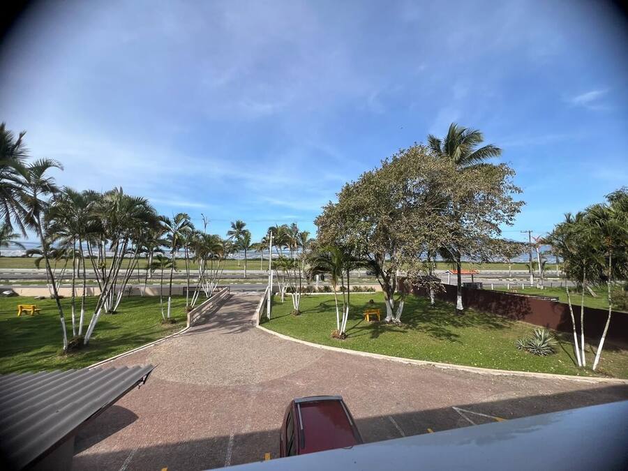 A paved pathway leading to a building with a clear sky.
