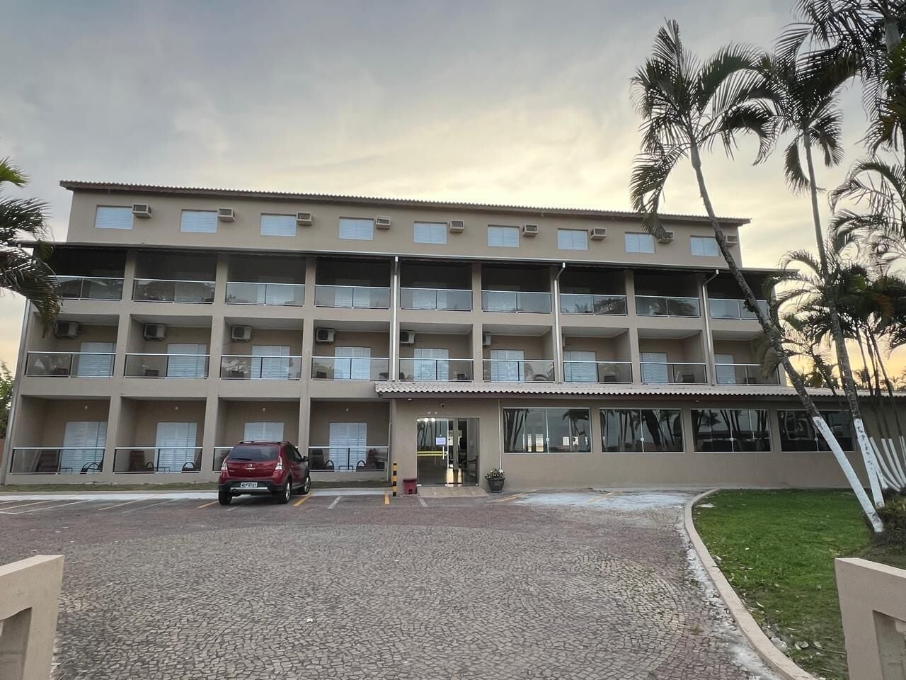 A multi-story building with a parking area in front.