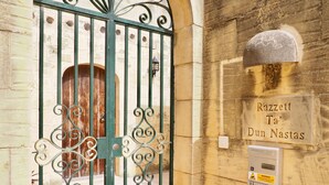 A wrought iron gate with a sign reading "Razzett Ta' Dun Nastas" and a CCTV warning sign. - Dun Nastas Farmhouse (Sannat)