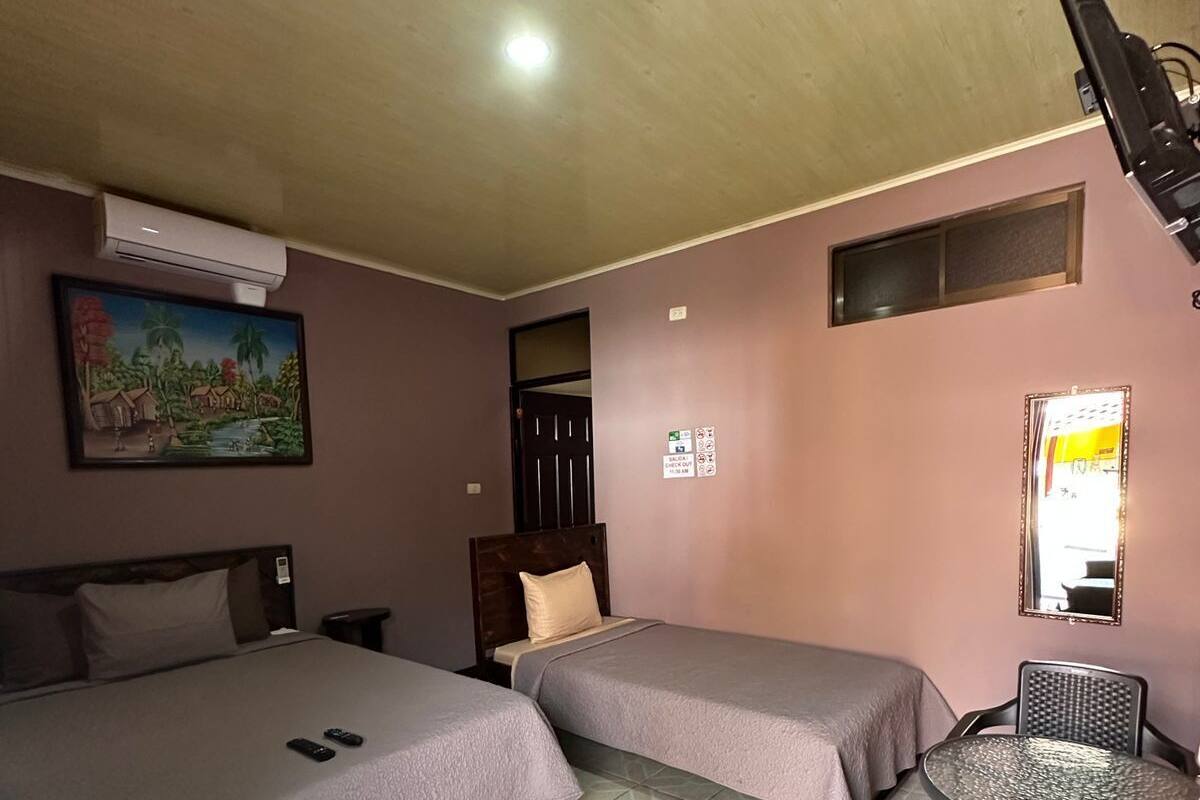 A room with two beds, a small table, and a chair.