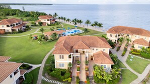 Un resort con varias edificaciones, una piscina y vista al océano.