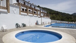 A circular pool with a tiled edge, surrounded by a concrete deck. There are white chairs and tables arranged around the pool. - La Mariquilla, rural housing in Jubrique, Valle del Genal, natural paradise ... (Jubrique)