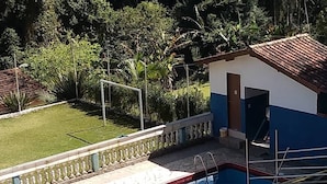 Una piscina amb aigua transparent i blava, envoltada per una taronja de maó i una barana blanca.