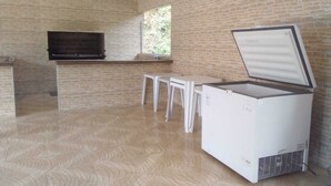 Cuina amb parets de maó, forn integrat, nevera i finestra.