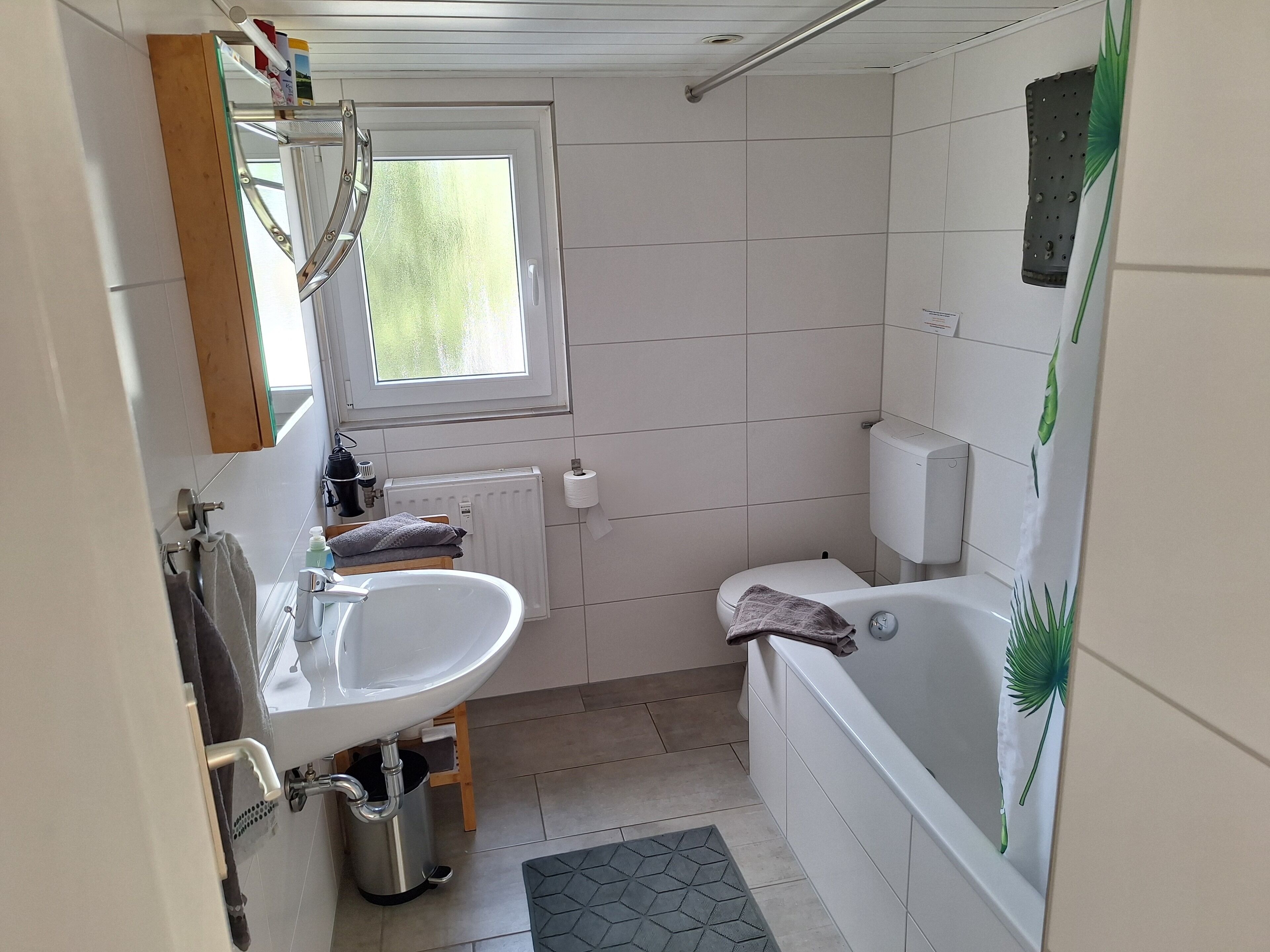 A small, clean bathroom with a sink, toilet, and bathtub.