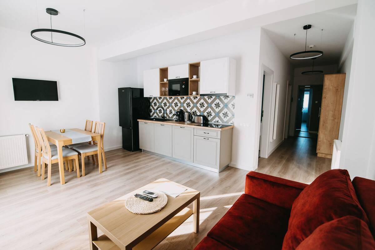 A modern apartment with a kitchen, dining area, and living room.