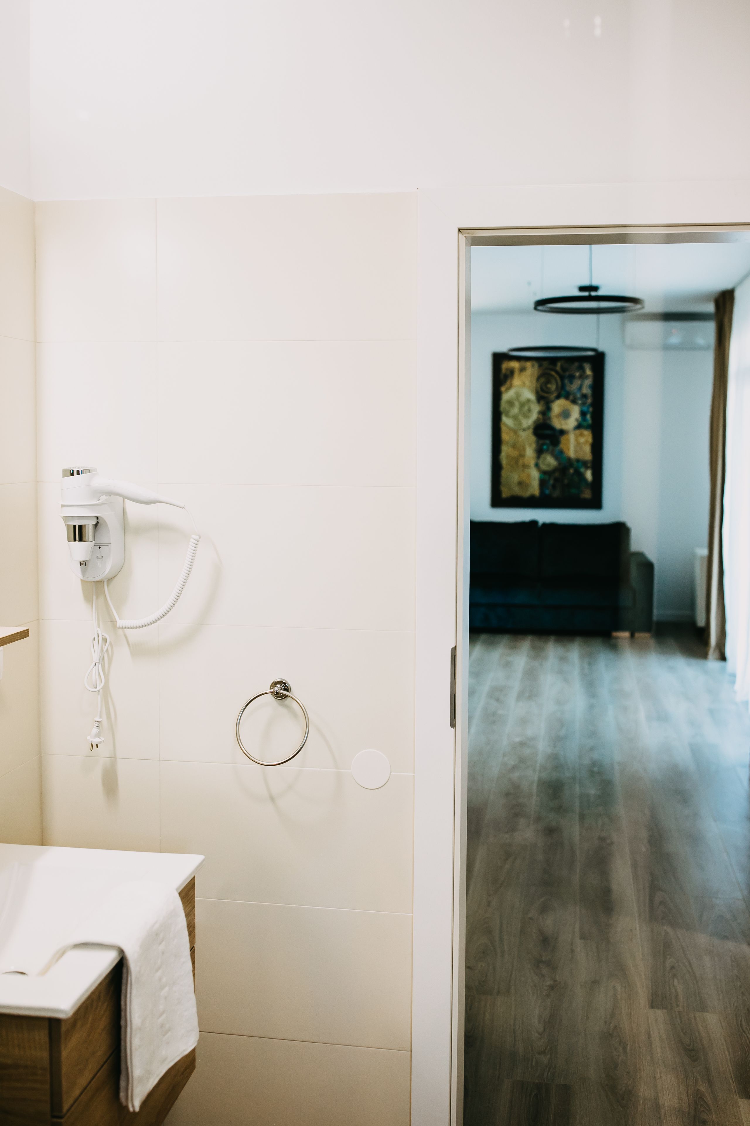 Une salle de bain équipée d’un porte-serviettes, d’un sèche-cheveux et de toilettes.