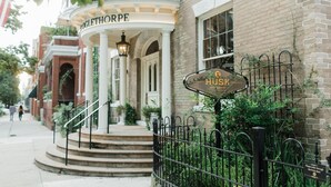 Un edificio histórico con un letrero que indica 'Husk Restaurant' y 'Oglethorpe' sobre la entrada.