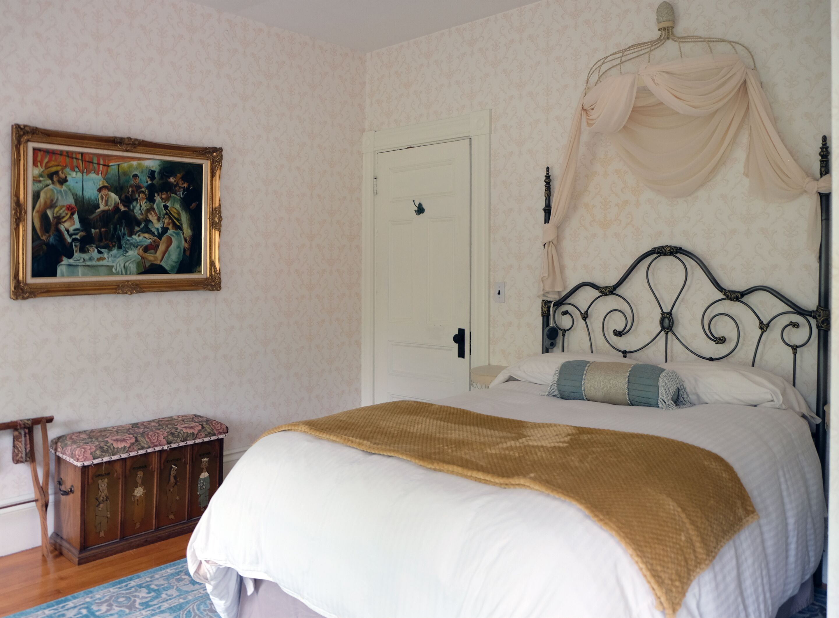 Un dormitorio con cama, mesita de noche, un cuadro y un armario.