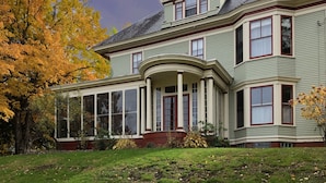A large, two-story house with a wrap-around porch and a large bay window. - Guilford Bed and Breakfast (Guilford)