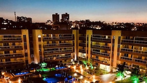 A hotel with multiple floors, outdoor pools, and well-lit pathways. - Flat na Praia do Futuro (Fortaleza)