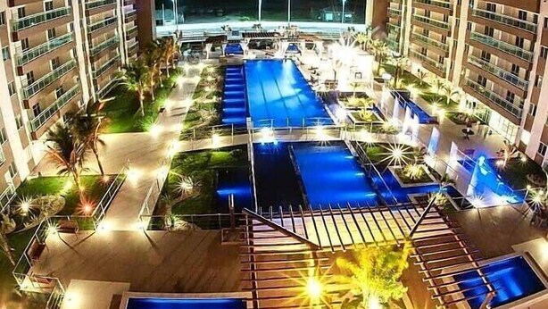 A hotel with multiple swimming pools, a central water feature, and well-lit outdoor areas. - Flat na Praia do Futuro (Fortaleza)