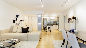 Una sala de estar moderna con un sofá, una mesa de centro y un comedor con sillas y una mesa.