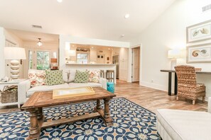 Relax in this stylish living space with a central coffee table, sofa, and wicker chair.