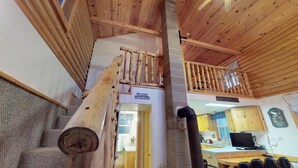 A wooden staircase with a log railing leading to a loft area. A sign reads "Welcome to the cabin." - The Cabin at Lydias Canyon (Glendale)