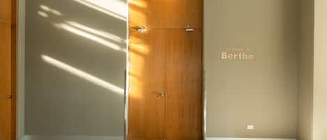 Un pasillo con una puerta de madera y un interruptor de luz en la pared.