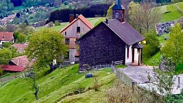 A rural landscape with a church and houses, surrounded by green fields and hills. - Chaletde montagne indépendant en Alsace Massif du Champ du Feu - Ski resort  (Bellefosse)
