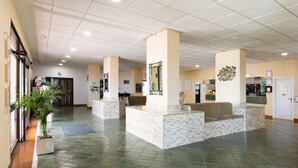 A spacious lobby with a reception desk, seating area, and a potted plant. - Apartment in Castle Harbor, heated pool, satellite TV channels (Los Cristianos)