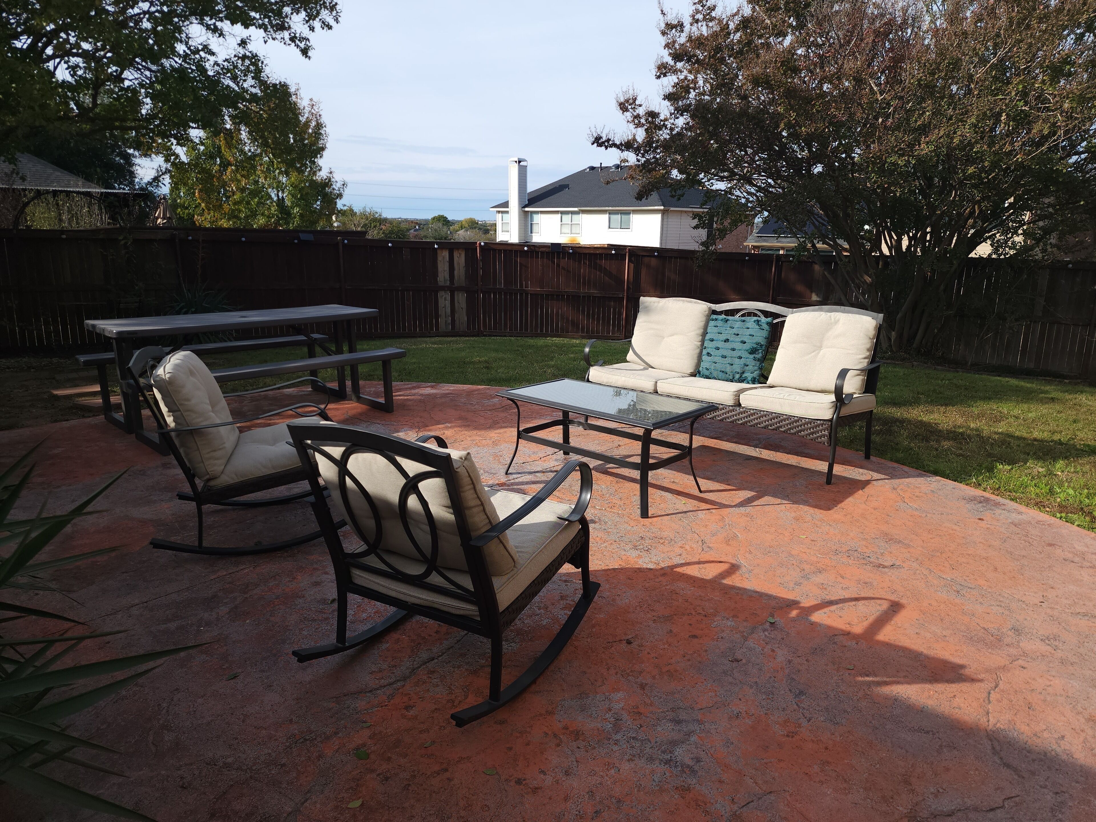 An outdoor patio with a table, chairs, and a sofa.