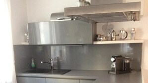 A modern kitchen with stainless steel appliances, a built-in oven, and a coffee maker. - very quiet apartment close to the sea and the center (Überlingen)
