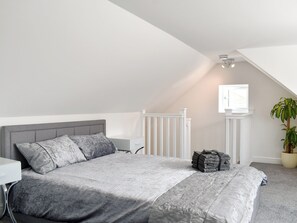 Une chambre à coucher avec un lit, une table de chevet, une fenêtre et une plante en pot.