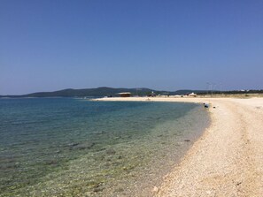 A beach with clear water, a sandy shore, and a distant mountain range. - Villa Angelina, Large Apartment Parterre (Brodarica, Kroatien)