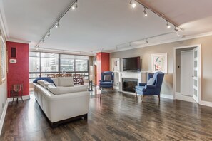 Relax in this stylish living area with a large sofa, two armchairs, and a flat-screen TV.