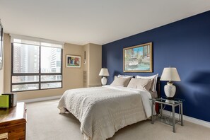 Enjoy a restful night's sleep in this stylish bedroom with a large bed and city views.