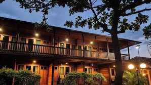 A two-story building with a wooden facade, multiple balconies, and a paved entrance area. - Hotel Besar Bulan Baru - Senggigi (Senggigi)