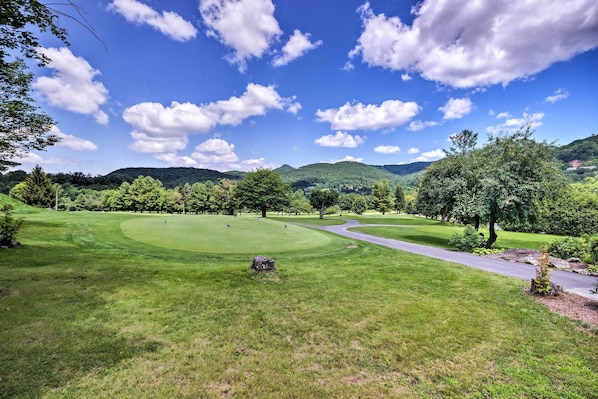 A golf course with a winding path, lush green grass, and trees. - Steps to Sugar Mountain! Condo w/ Furnished Deck (Sugar Mountain)