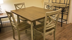 Un comedor con una mesa de madera y cuatro sillas.